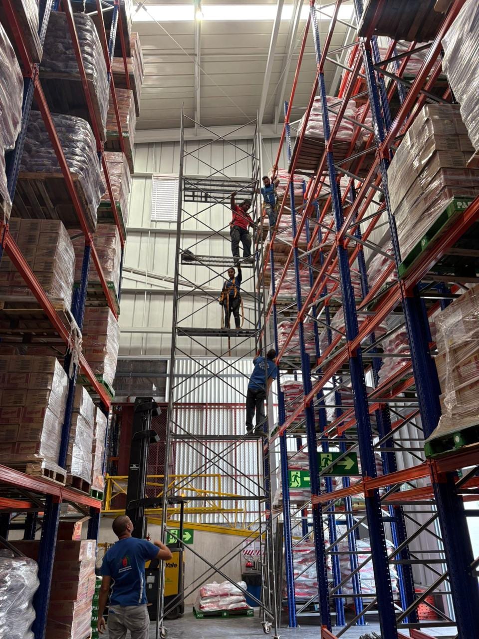 Iluminación Industrial en Bodega — Luminarias High Bay instaladas en altura con andamiaje certificado
