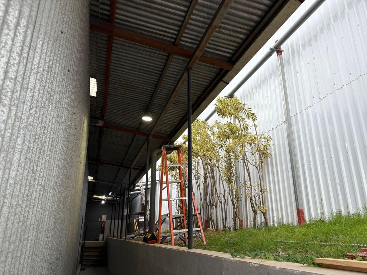 Iluminación Industrial en Bodega — Luminarias High Bay instaladas en altura con andamiaje certificado